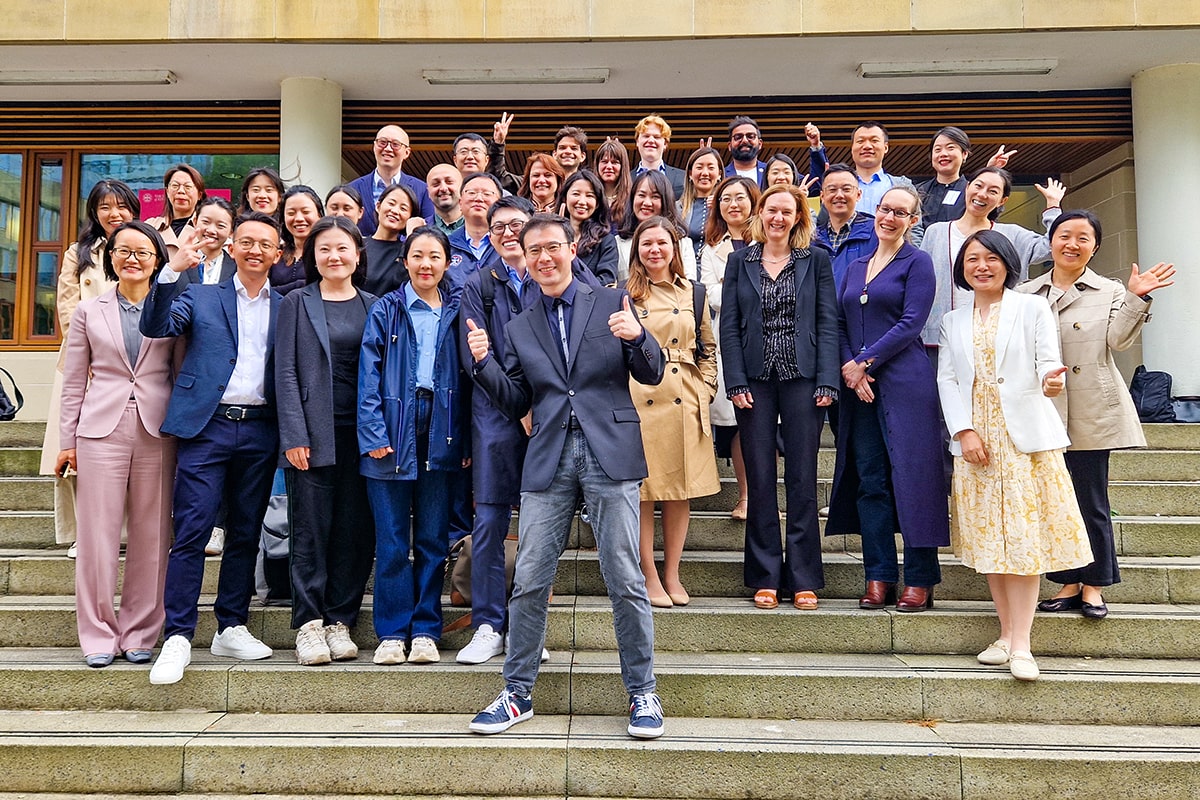 Group of around 30 participants on the Rainforest Foundation Norway executive education programme, standing on the steps of the Business School