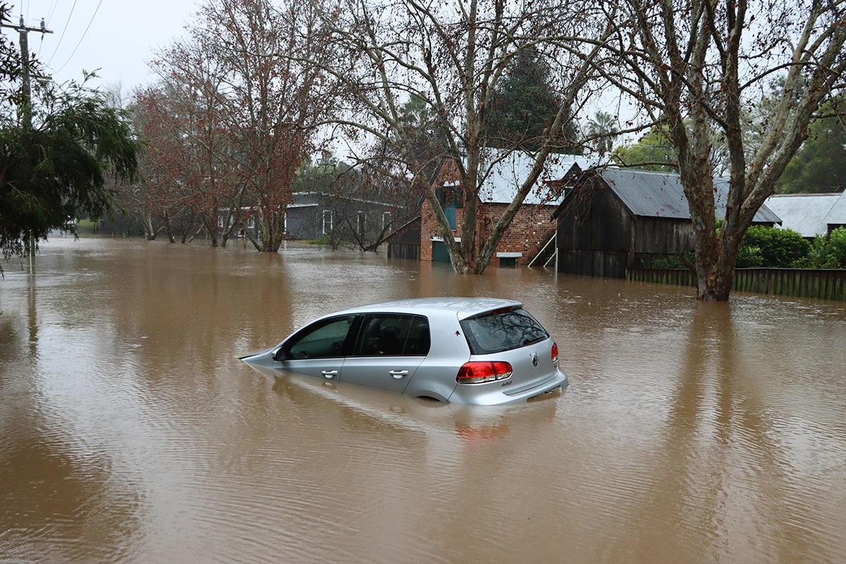 Half-submerged car in a flooded street.