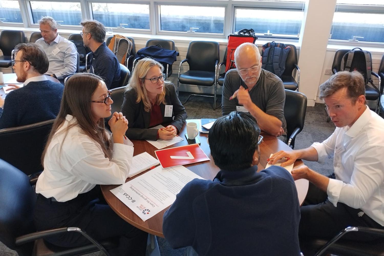 A group of people sitting round a table talking