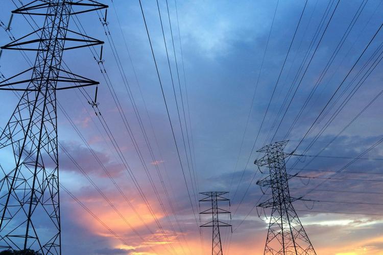 Electricity pylons against a sunset sky